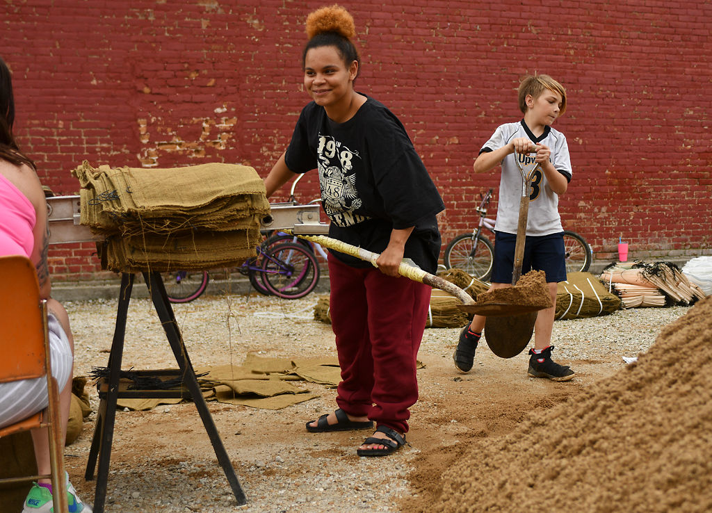 Columbia local Tasheia Carter and Isaak Rand shovel dirt into sandbags